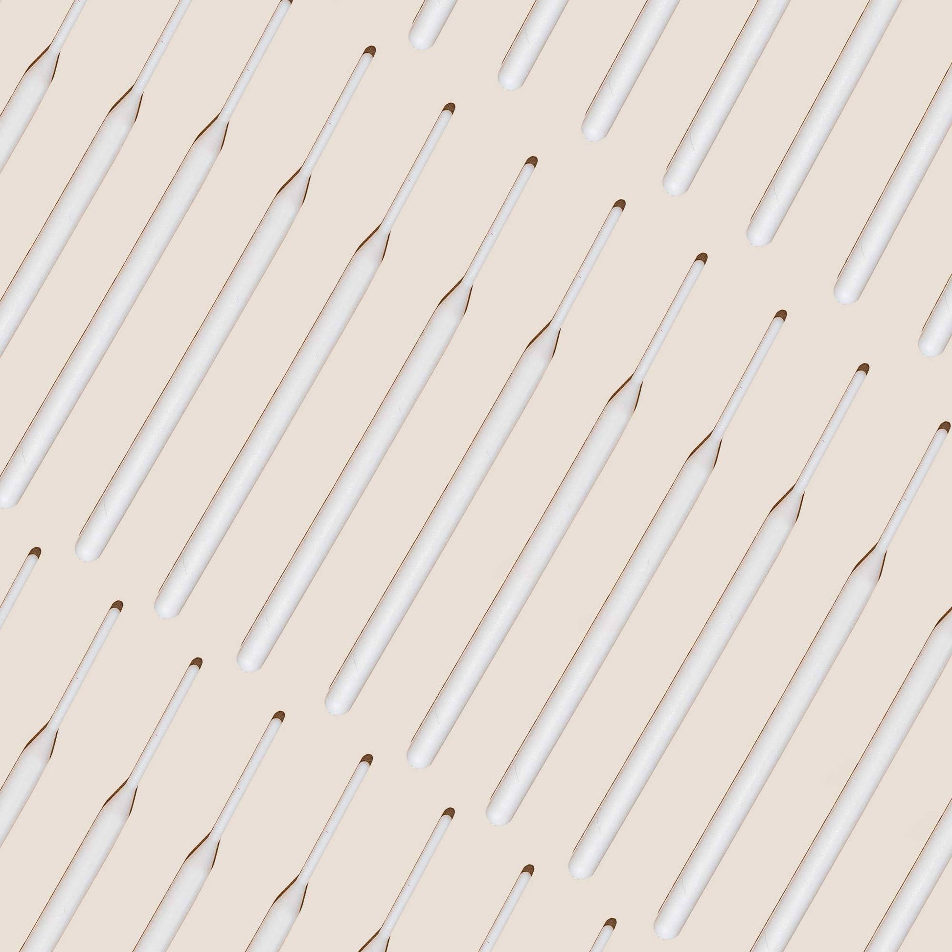 Numerous tinting sticks laid out against an off white background